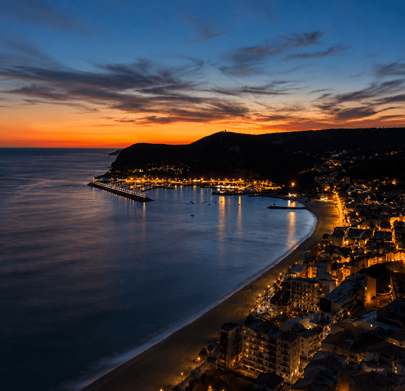 Vista aérea de Sesimbra ao pôr do sol com a serra da Arrábida